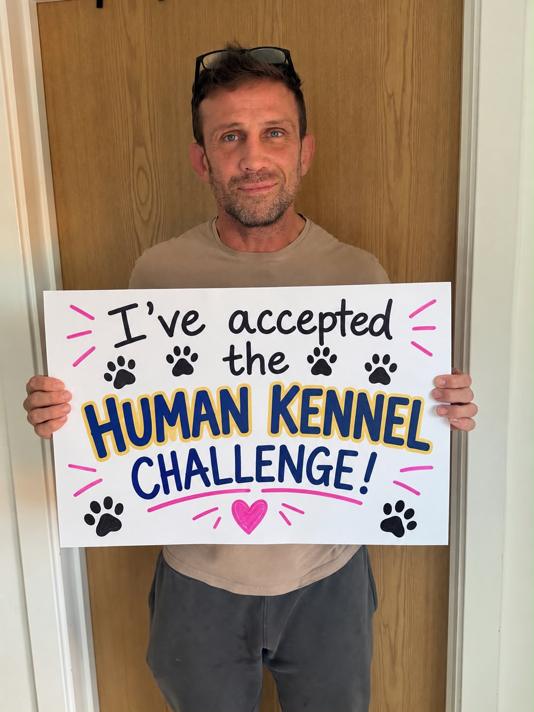 Alex Reid holding his "I've accepted the Human Kennel Challenge" board