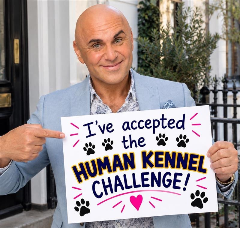 Simon Gross pointing at his "I've accepted the Human Kennel Challenge" board