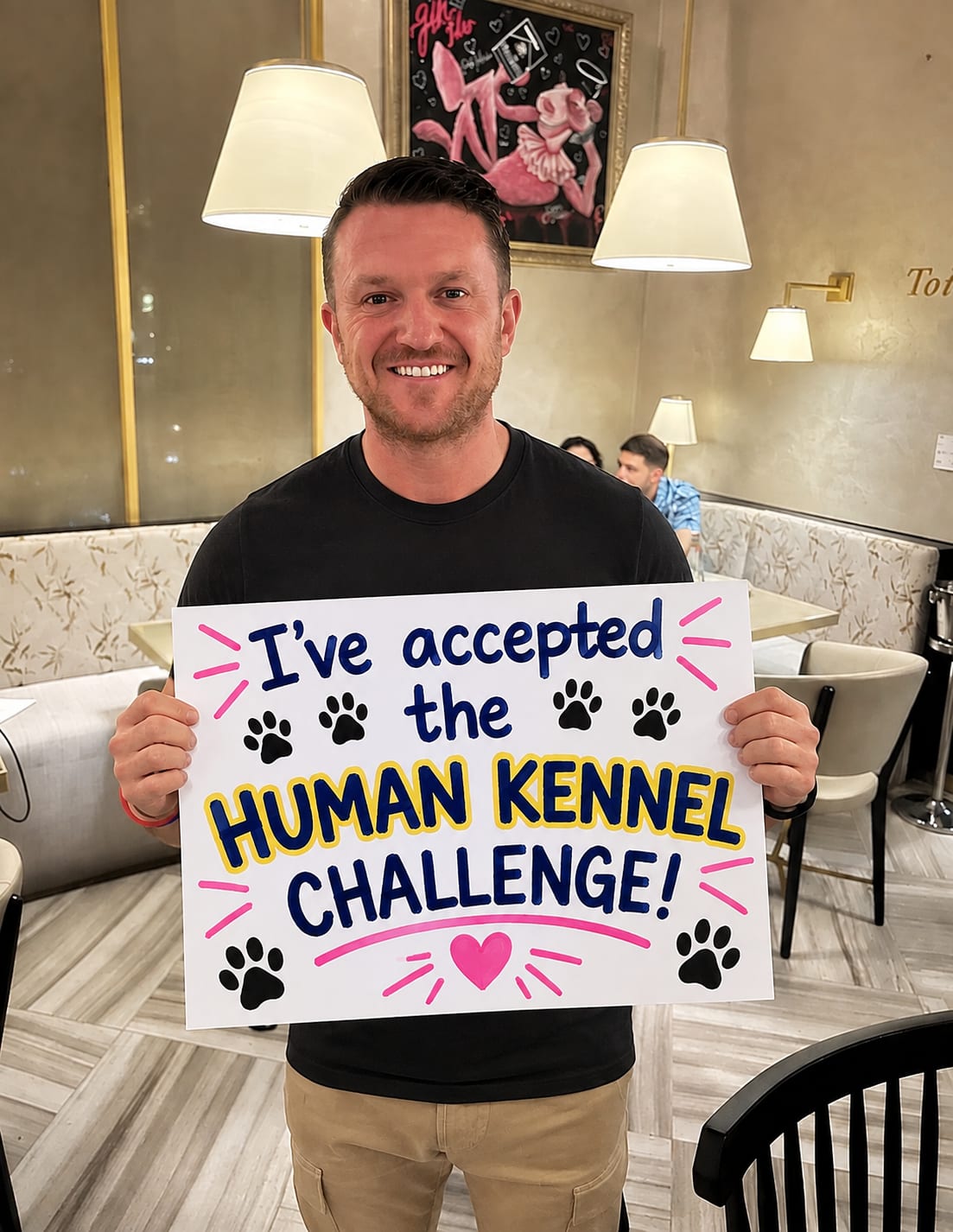 Tommy Robinson holding his "I've accepted the Human Kennel Challenge" board